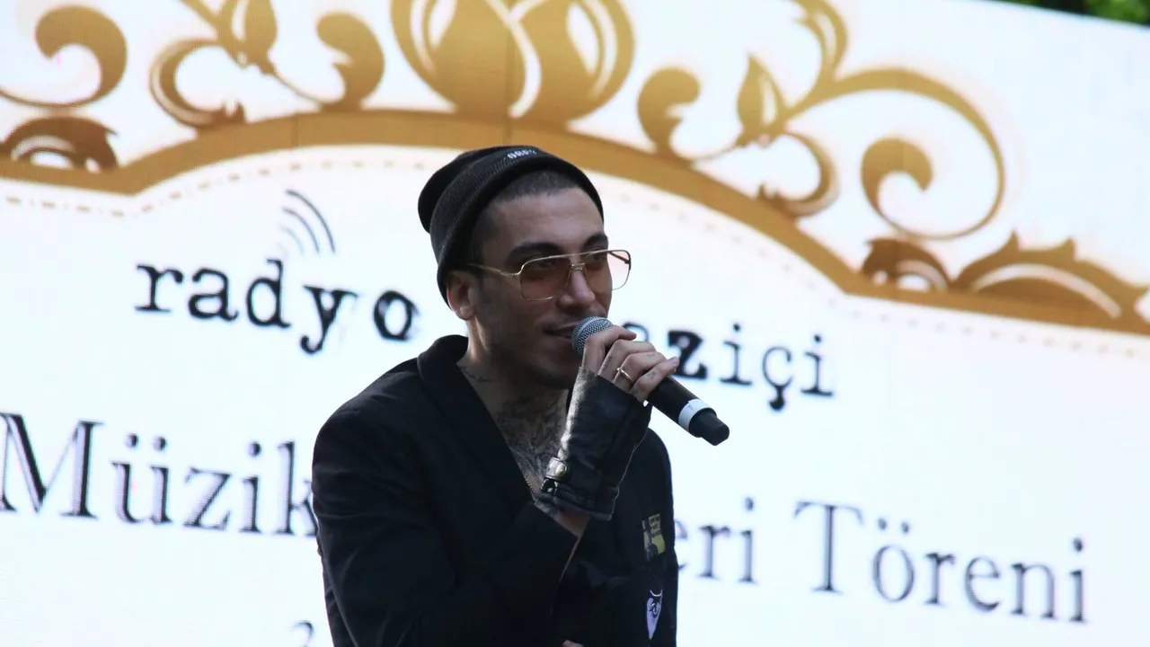 Can Bonomo bir ödül töreninde sahnede mikrofonla konuşurken